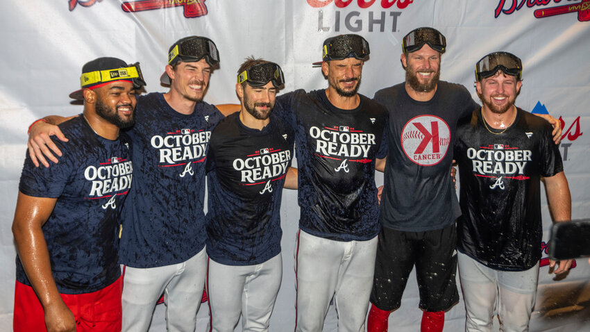 Atlanta Braves players celebrate in the locker room after clinching a wild-card playoff berth by winning the second game of a doubleheader against the New York Mets, Monday, Sept. 30, 2024, in Atlanta. (AP Photo/Jason Allen)