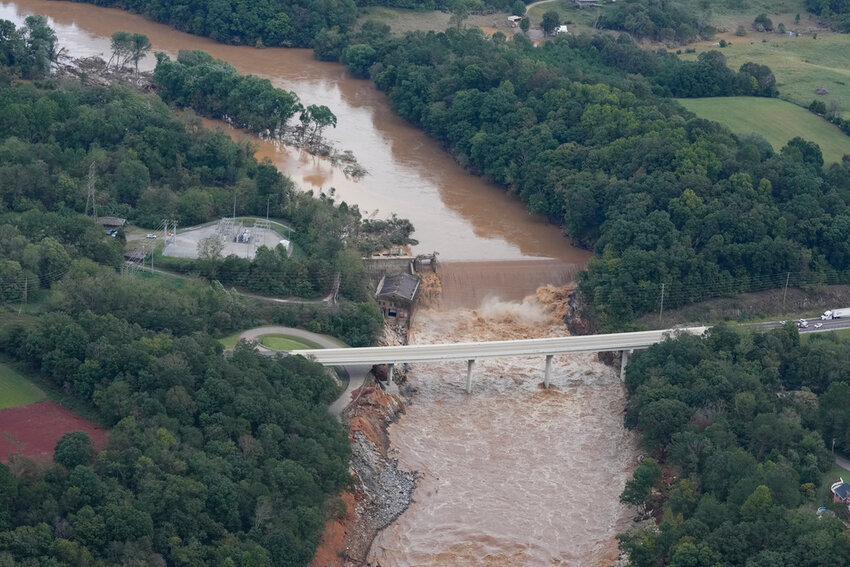 An aerial view of the Nolichucky Dam shows water from the Nolichucky River flowing over the top after Hurricane Helene brought heavy rains to the area Saturday, Sept. 28, 2024, in Greene County, Tenn. (AP Photo/George Walker IV)