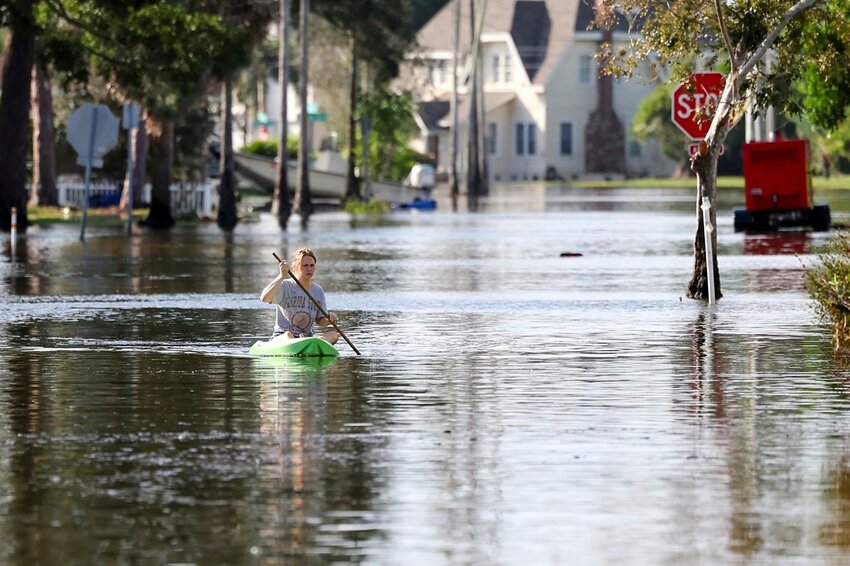 Halle Brooks kayaks down a street flooded by Hurricane Helene in the Shore Acres neighborhood Sept. 27, 2024, in St. Petersburg, Fla. (AP Photo/Mike Carlson, File)