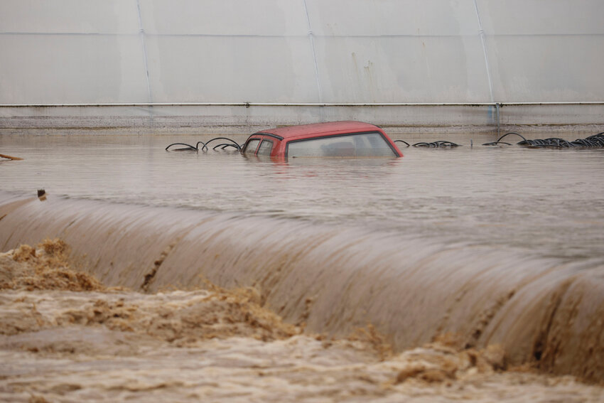 A car is submerged in flood waters outside an apartment building in the village of Kiseljak, northern Bosnia, Friday, Oct. 4, 2024. (AP Photo/Armin Durgut)