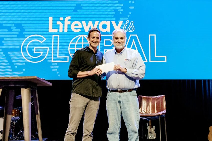 Lifeway President and CEO Ben Mandrell presents Mike Cowles, director of major gifts for Nashville Rescue Mission, with a check for $70,000 from donations by employees. (Lifeway/Kate Neelly)