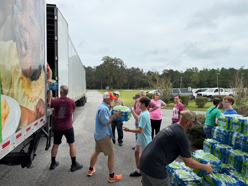 In preparation for drive-thru distribution to more than 600 community residents in need, Hopeful Baptist Church members form an assembly line to unload water from the One More Child truck. (Photo/Florida Baptist Convention)