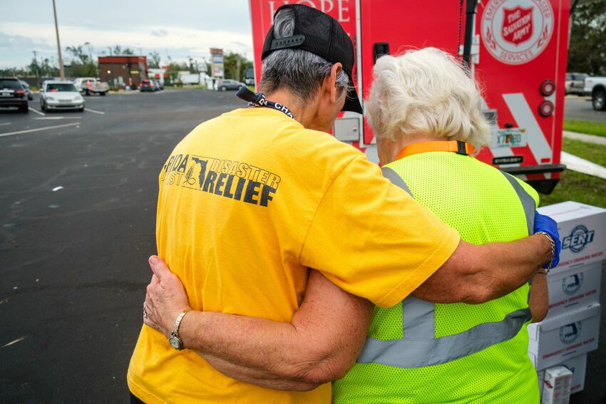 Diane Traynor, a member of Murdock Baptist Church in Port Charlotte, Fla., wraps her arm around and prays with a woman who received a hot meal during relief efforts following Hurricane Helene’s landfall. (Florida Baptist Convention/William Haun)