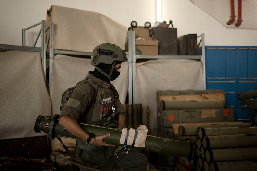 An Israeli soldier from an explosive ordnance disposal unit moves a weapon used by Hezbollah, seized during combat operations in Lebanon and displayed during a government-organized media tour on a base in southern Israel, Wednesday, Oct. 9, 2024. (AP Photo/Maya Alleruzzo)