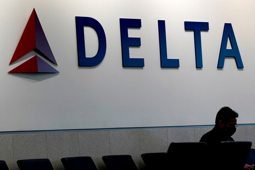 A man waits for a Delta Airlines flight at Hartsfield-Jackson International Airport in Atlanta, Jan. 7, 2022. (AP Photo/Charlie Riedel, File)