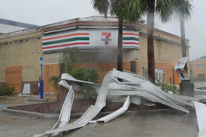 An apparent tornado caused by Hurricane Milton tore the awning off a 7-Eleven convenience store, Wednesday, Oct. 9, 2024, in Cape Coral, Fla. (AP Photo/Marta Lavandier)