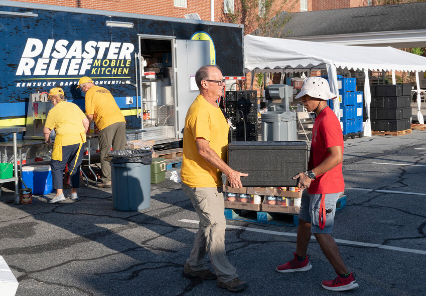 Valdosta State University BCM student Alessio Williams, right, helps a Disaster Relief volunteer from Kentucky carry a container of hot food at Northside Baptist Church in Valdosta, Ga., Wednesday, Oct. 2, 2024. (Index/Henry Durand)