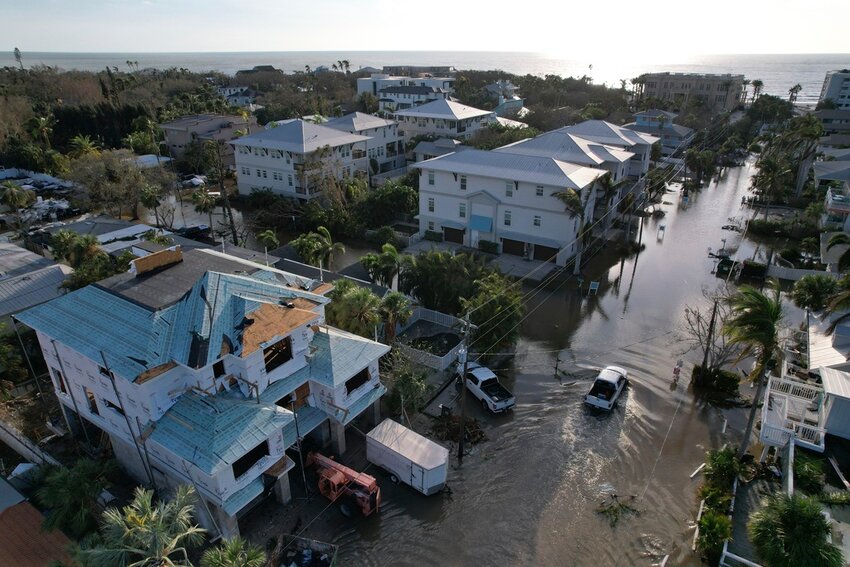 A truck drives down a flooded street in Siesta Key, Fla., following the passage of Hurricane Milton, Oct. 10, 2024. (AP Photo/Rebecca Blackwell)