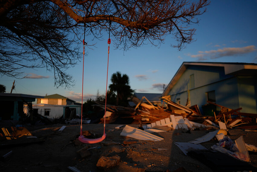 A child's swing still hangs on a tree, surrounded by debris from homes destroyed by Hurricane Milton, on Manasota Key, Fla., Saturday, Oct. 12, 2024. (AP Photo/Rebecca Blackwell)