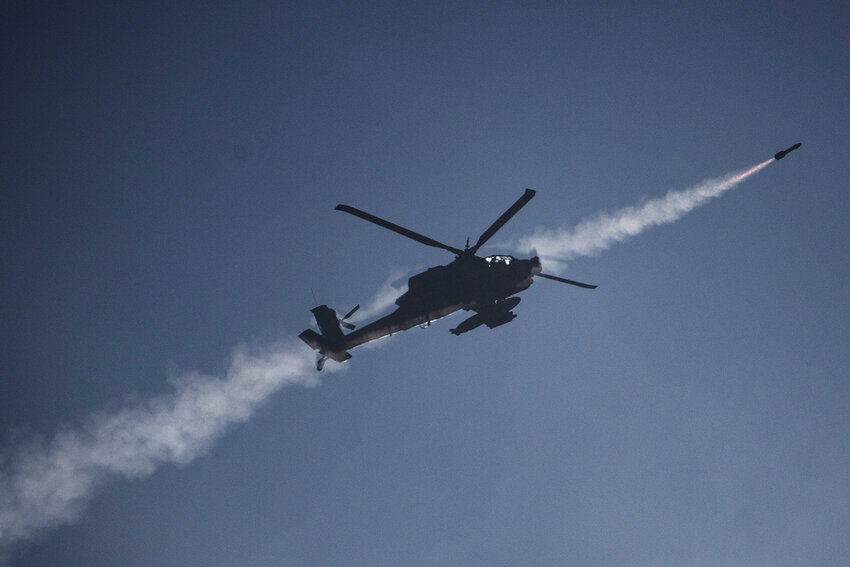 An Israeli Apache helicopter fires a missile towards southern Lebanon as seen from northern Israel, Sunday, Oct. 13, 2024. (AP Photo/Leo Correa)