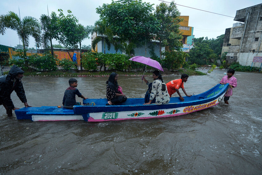 People use a boat on a flooded street to reach safer place during heavy rains in Chennai, India, Wednesday, Oct.16, 2024. (AP Photo/Mahesh Kumar A.)