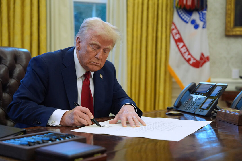 President Donald Trump signs a document in the Oval Office at the White House, Jan. 30, 2025, in Washington. (AP Photo/Evan Vucci, File)