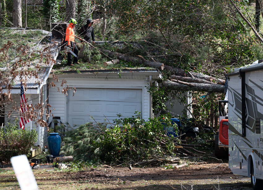 Workers remove a fallen tree from atop a house in Dallas, Ga., Sunday, March 16, 2025. A tornado hit the county late Saturday, according to the National Weather Service, causing damage but no fatalities. (Index/Henry Durand)