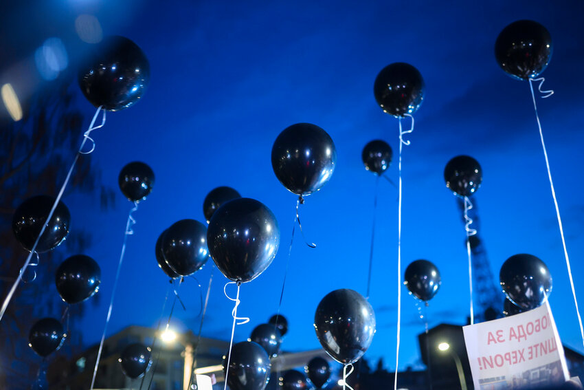 People taking part in a protest hold balloons in the town of Kocani, North Macedonia, Tuesday, March 18, 2025, following a massive fire in a nightclub early SUnday. (AP Photo/Armin Durgut)