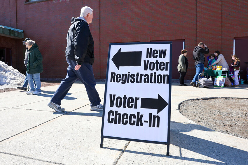 A sign for new voter registration is seen outside a polling location at Pinkerton Academy in Derry, N.H., March 11, 2025. (AP Photo/Reba Saldanha, File)