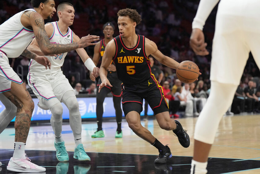 Atlanta Hawks guard Dyson Daniels (5) drives to the basket as Miami Heat guard Tyler Herro (14) and center Kel'el Ware, left, defend during the first half Thursday, March 27, 2025, in Miami. (AP Photo/Jim Rassol)