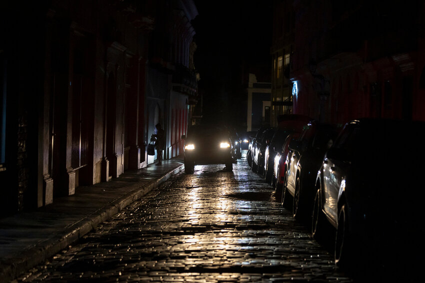 Headlights illuminate cobblestone streets in Old San Juan, Puerto Rico, during an island-wide blackout, Wednesday, April 16, 2025. (AP Photo/Alejandro Granadillo)