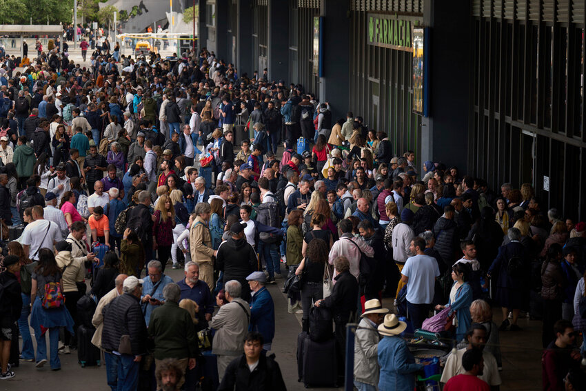 People wait outside a closed train station, during a  major power outage in Barcelona, Spain, Monday, April 28, 2025. (AP Photo/Emilio Morenatti)