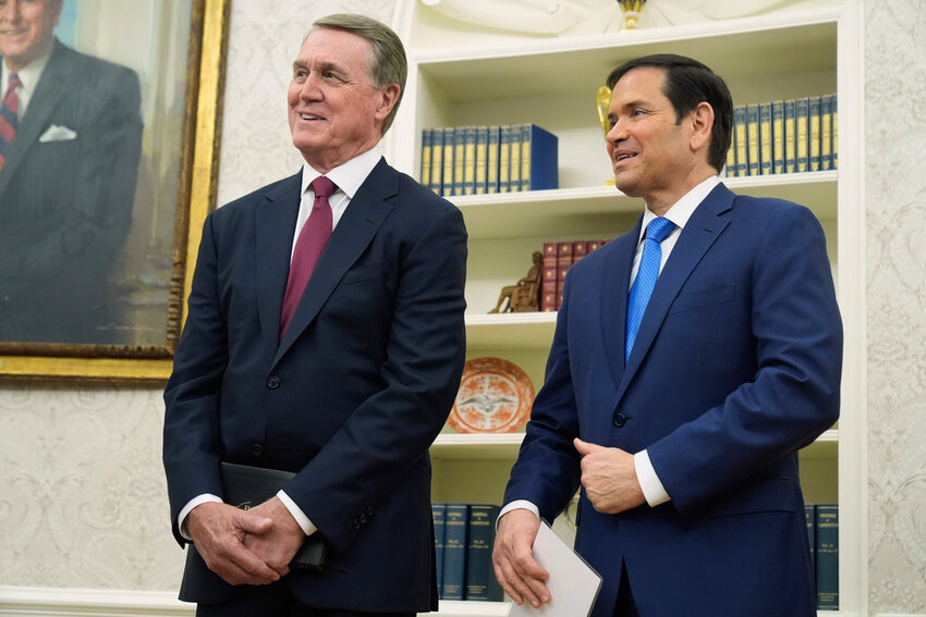 David Perdue and Secretary of State Marco Rubio listen as President Donald Trump speaks before Perdue was sworn in as U.S. Ambassador to China during a ceremony in the Oval Office of the White House, May 7, 2025, in Washington. (AP Photo/Mark Schiefelbein)