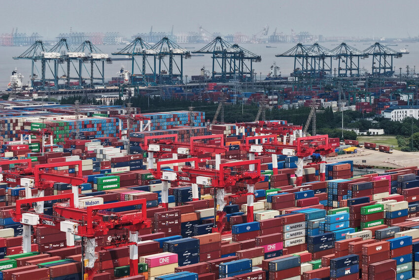 Trucks loaded with containers move through a container terminal port in Shanghai, China, Monday, June 9, 2025. (Chinatopix Via AP)