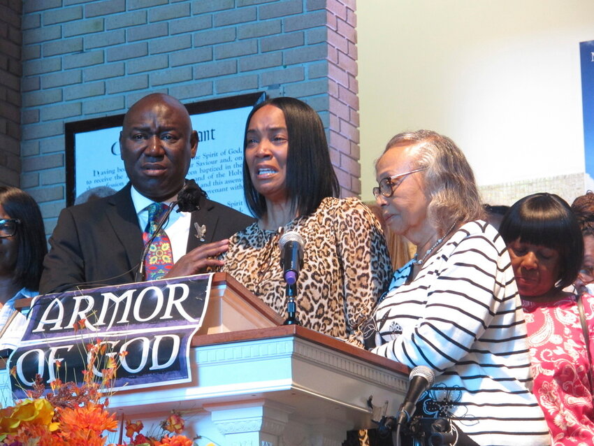 Regina Brinson, center, weeps at a news conference Tuesday, Oct. 22, 2024, while speaking alongside her mother, Katrena Alexander and attorney Ben Crump during a news conference in Jacksonville, Fla. Crump represents families of three of the seven people killed when a ferry dock walkway collapsed on Sapelo Island, Ga., on Oct. 19. (AP Photo/Russ Bynum)