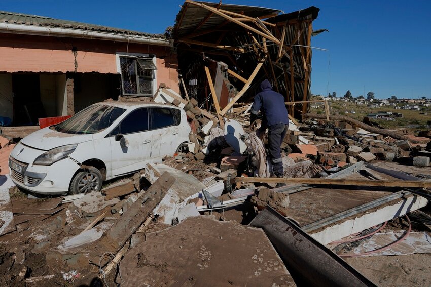 A resident looks through the remnants after floods swept through the area in Mthatha, South Africa, Thursday, June 12, 2025. (AP Photo/Themba Hadebe)