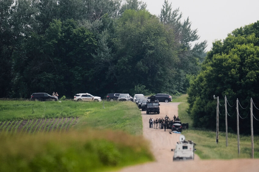 Members of law enforcement agencies investigate near a vehicle suspected to belong to shooting suspect Vance Boelter, Sunday, June 15, 2025, in Belle Plaine, Minn. (AP Photo/George Walker IV)