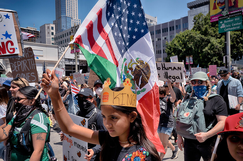 A young girl carries a combination Mexican and U.S. flag during a protest in downtown Los Angeles on Saturday, June 14, 2025. (AP Photo/Richard Vogel)