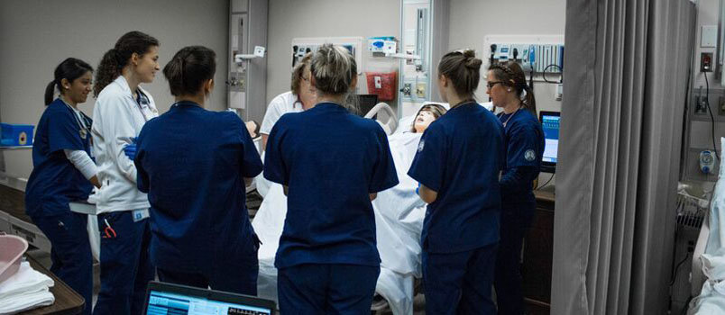 TMU nursing students along with Professor Lisa LaPree discuss proper labor and delivery procedures in the simulation lab. TMU/Special