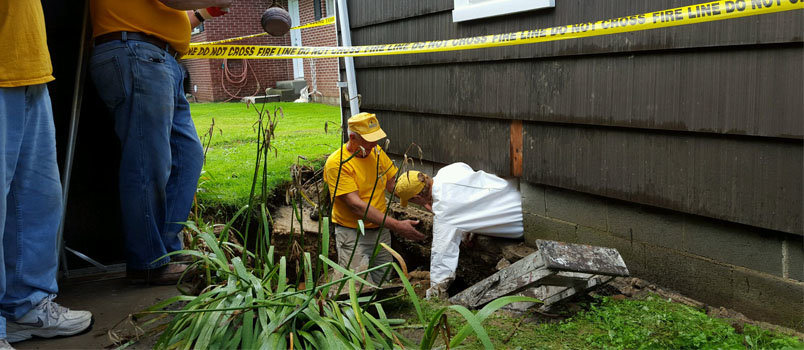 Tom Young assists Lori Moreland exiting a crawl space after photographing possible structural issues for a Mt. Nebo, WV homeowner. In all, five teams of Georgia Baptist Disaster Relief volunteers joined in efforts to help West Virginia residents still recovering from June floods. GBDR/Special