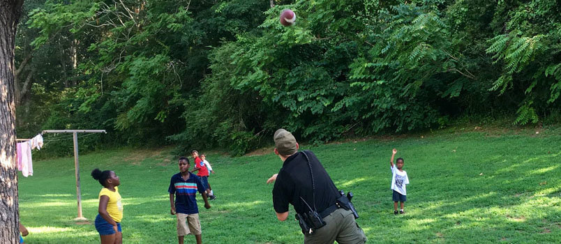 Law enforcement officers toss a football with children. CASEY HARPE/Special