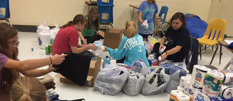 Sheilah Daws, in black, helps youth assemble food packets for refugees in mid-Georgia. Daws is wife of Dudley Baptist pastor Billy Daws. DUDLEY BAPTIST/Special