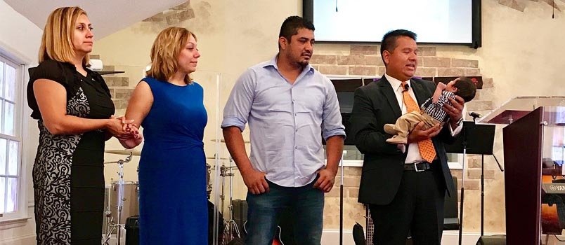 Javier Chavez, right, dedicates an infant at Amistad Cristiana International Church in  Gainesville. ACIC/Special