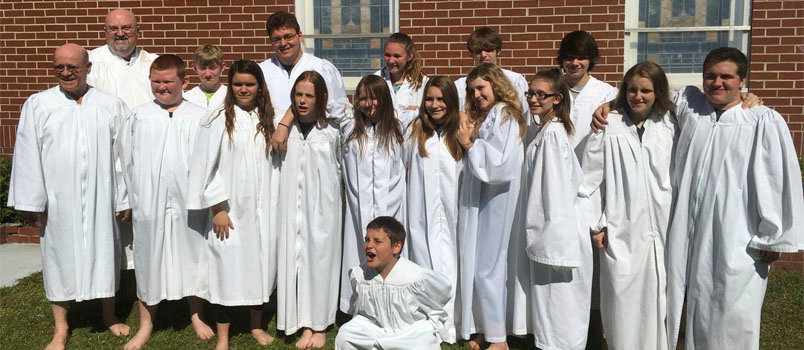 Johnny Gross and Aaron Webb, left, stand with the students baptized on Easter Sunday. NEWINGTON BAPTIST CHURCH/Special
