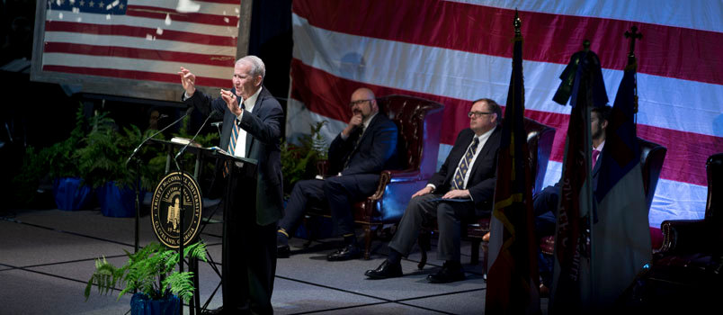 Lt. Colonel Oliver North addresses the crowd while, left to right, TMU President Emir Caner, Todd Starnes of FOX News, and singer Jake Cowley sit on the stage. JENNY GREGORY/TMU