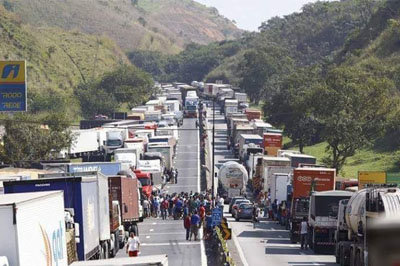 Brazil truckers during a blockade Tuesday. Truckers and others are striking because Petrobras, the state-controlled oil company, has gradually increased diesel prices — by more than 40 percent — over six months, at the same time that the Temer administration has substantially hiked fuel taxes. ,a href="https://www.joc.com/port-news/south-american-ports/port-santos/about-300000-brazil-truckers-block-roads-protest-fuel-hikes-delaying-cargo_20180523.html">ROB WARD/joc.com
