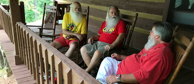 A group of Santas, part of Kaleo's first hosted Clown Academy, rest on the porch outside the dining hall in August.  JOE WESTBURY/Index