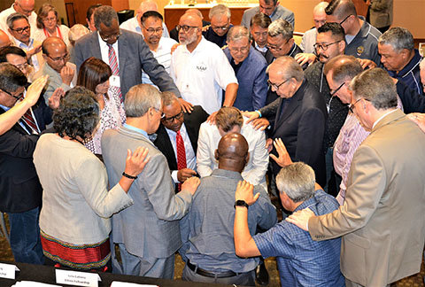 Marshal Ausberry, kneeling in red tie, led a prayer for Southern Baptist Convention Executive Committee President Ronnie Floyd, kneeling center, at the Aug. 2 meeting of the Convention Advancement Ethnic Fellowship. Ausberry is president of the National African American Fellowship of the SBC. RIC WORSHILL/BP