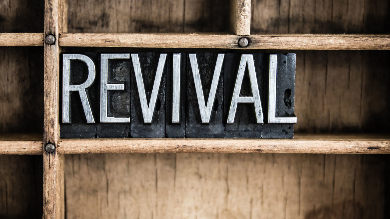 The word "REVIVAL" written in vintage metal letterpress type in a wooden drawer with dividers.