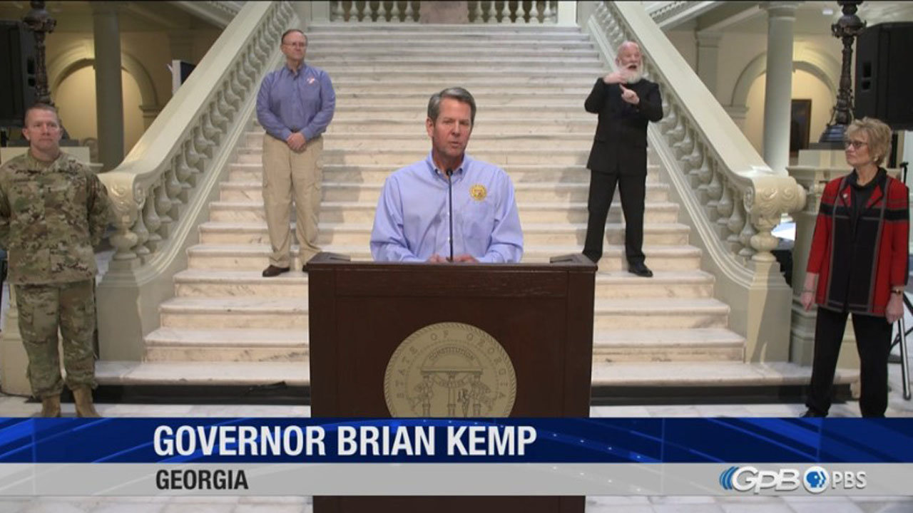 Governor Brian Kemp announces updated restrictions related to the coronavirus crisis at the Georgia State Capitol on April 8. Standing at right is Dr. Kathleen Toomey, commissioner of the Georgia Department of Public Health.
