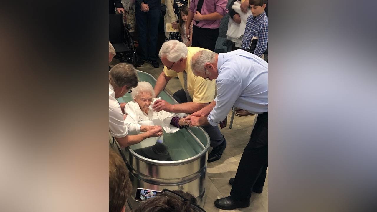 Pastor Fred McCoy (in the yellow shirt) secured a galvanized container and used it to baptize a 97-year-old woman who recently trusted Christ as Savior. COURTESY/Gerald Harris