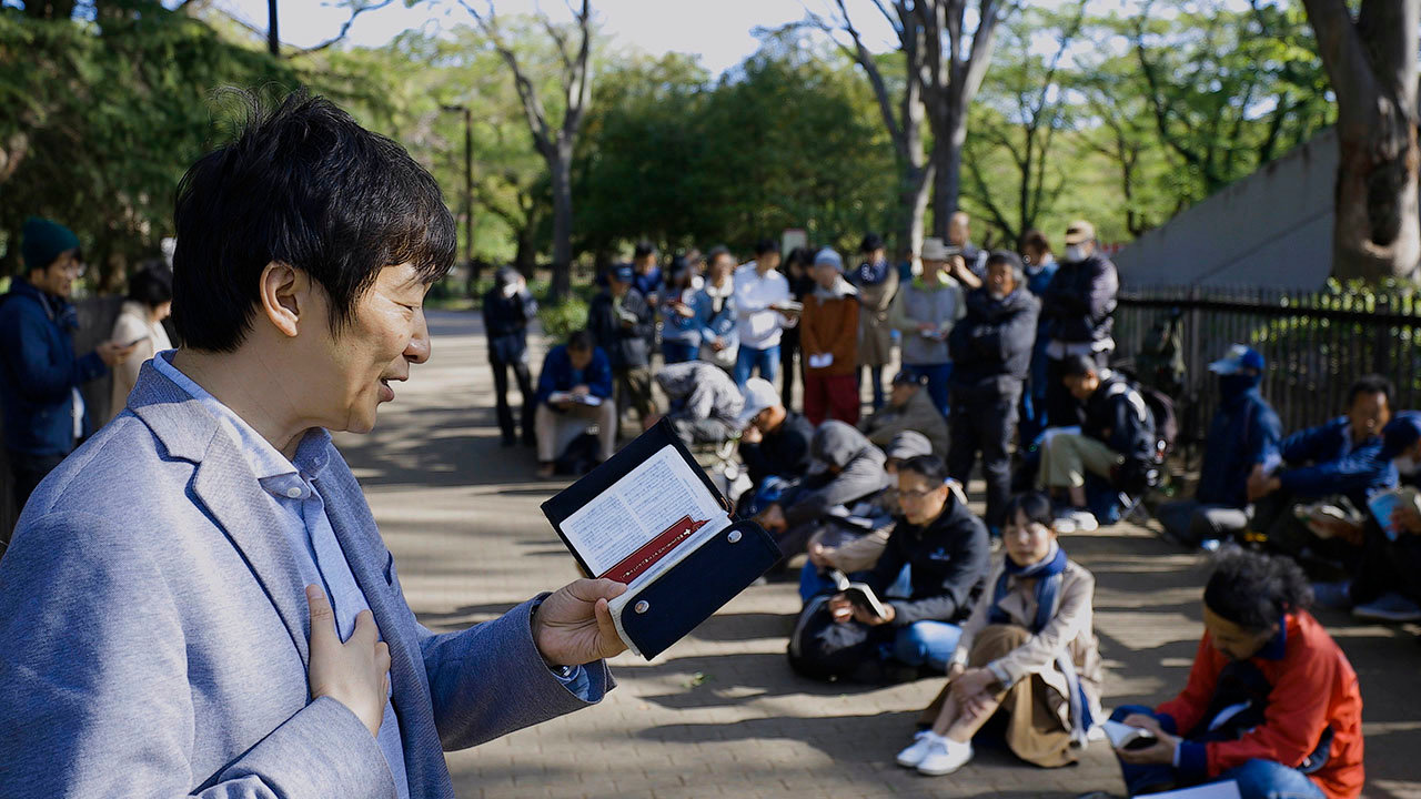 A Japanese pastor preaches to homeless men and women in Yoyogi Park in Tokyo. Every week, between 80 and 100 homeless people show up for sidewalk chapel in the park to eat a free meal and hear the Gospel. IMB
