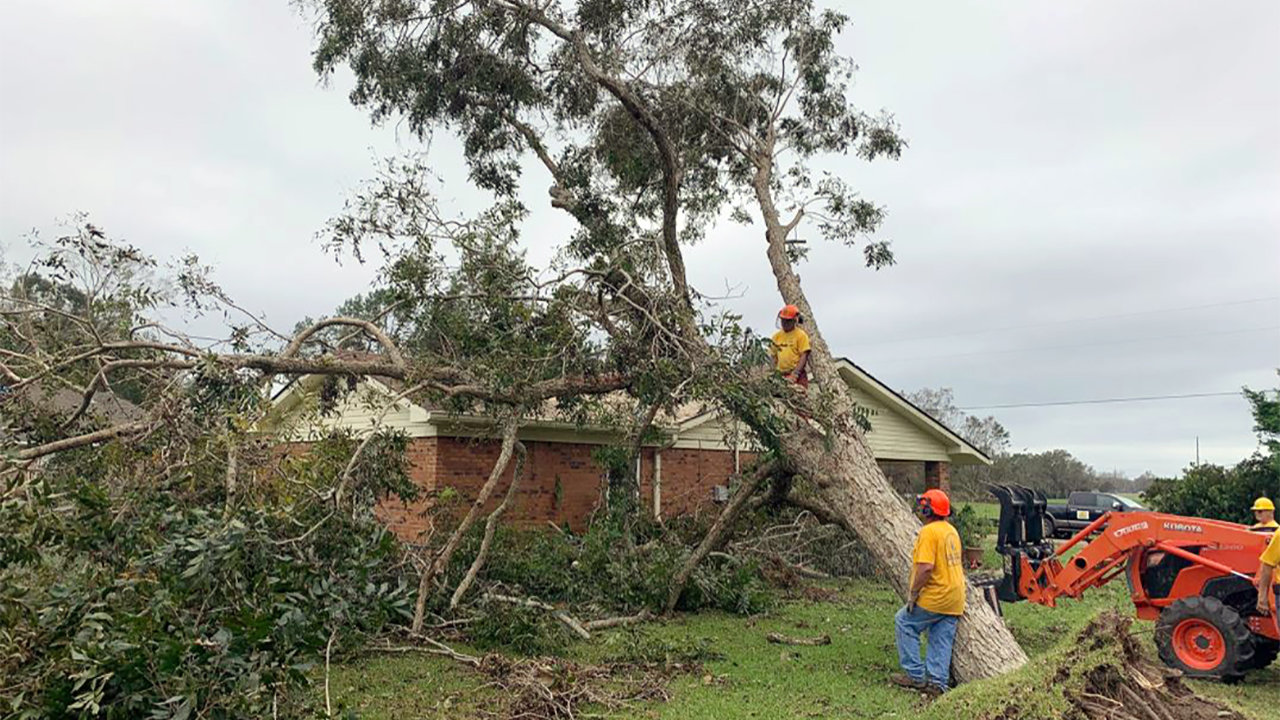 A Southern Baptist volunteer disaster relief team removes a downed tree from a home in Silverhill, Ala., following Hurricane Sally. RNS/Bob Smietana