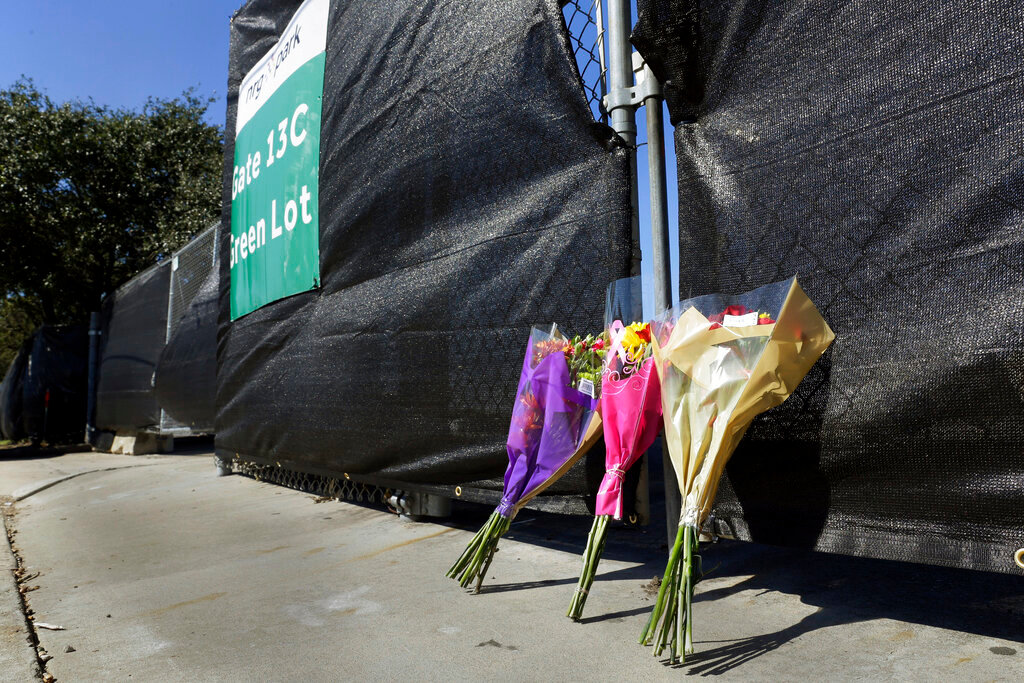 Flowers lay against the south fence surrounding the Astroworld festival grounds the day after at least eight died and scores were injured during a concert by rapper Travis Scott at his two day event, held at NRG Park Saturday, Nov. 6, 2021, in Houston. (AP Photo/Michael Wyke)..