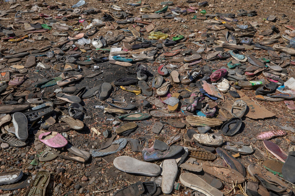 FILE - Shoes left behind belonging to Tigrayan refugees are scattered near the banks of the Tekeze River on the Sudan-Ethiopia border after Ethiopian forces blocked people from crossing into Sudan, in Hamdayet, eastern Sudan, Dec. 15, 2020. Thousands have died in Ethiopia's brutal year-long war that began in Tigray. The death toll is one of the biggest unknowns of the war. (AP Photo/Nariman El-Mofty, File)