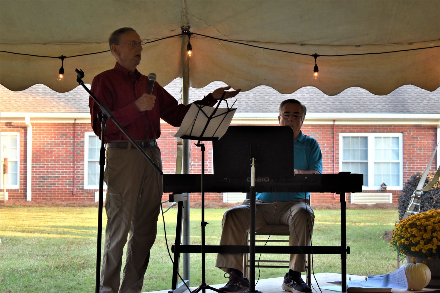 Shaded beneath a tent, Georgia Baptists lead an outdoor revival at a senior living center in Palmetto, Ga.