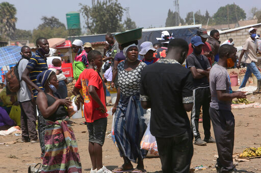 People are seen at a busy market in a poor township on the outskirts of the capital Harare, Monday, Nov, 15, 2021. When the coronavirus first emerged last year, health officials feared the pandemic would sweep across Africa, killing millions and destroying the continent’s fragile health systems. Although it’s still unclear what COVID-19’s ultimate toll will be, that catastrophic scenario has yet to materialize in Zimbabwe or much of Africa. (AP Photo/Tsvangirayi Mukwazhi)