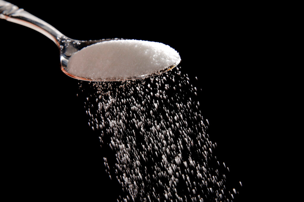 Granulated sugar is poured in Philadelphia, Sept. 12, 2016. The Justice Department filed a lawsuit on Tuesday, Nov. 23, 2021, seeking to block a major U.S. sugar manufacturer from acquiring its rival, arguing that allowing the deal would harm competition and consumers. (AP Photo/Matt Rourke, File)
