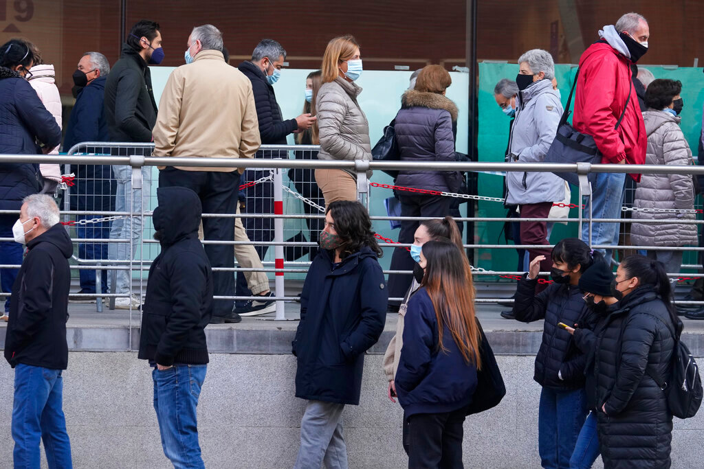 People queue for Pfizer COVID-19 vaccinations in the Wizink Center in Madrid, Spain, Wednesday, Dec. 1, 2021. Health authorities in the Spanish capital have confirmed a second case of the omicron coronavirus variant in a 61-year-old woman who had returned from a trip to South Africa on Monday. (AP Photo/Paul White)