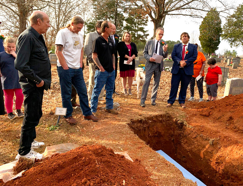 Family and friends gather for a funeral for Alabama death row inmate Doyle Lee Hamm at a cemetery in Cherokee, Ala., on Friday, Dec. 3, 2021. Hamm survived an execution attempt in 2018 and died years later of natural causes. He was laid to rest in a grave dug by family and friends, his lawyer said. (Fonda Shen via AP)